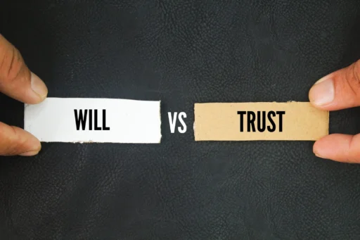 Two hands holding paper labels reading “Will” and “Trust” on a black background, symbolizing a comparison between estate planning tools.