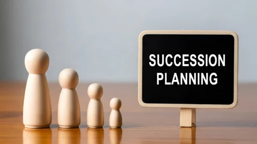 Wooden family figures lined up beside a small sign that reads “Succession Planning.”