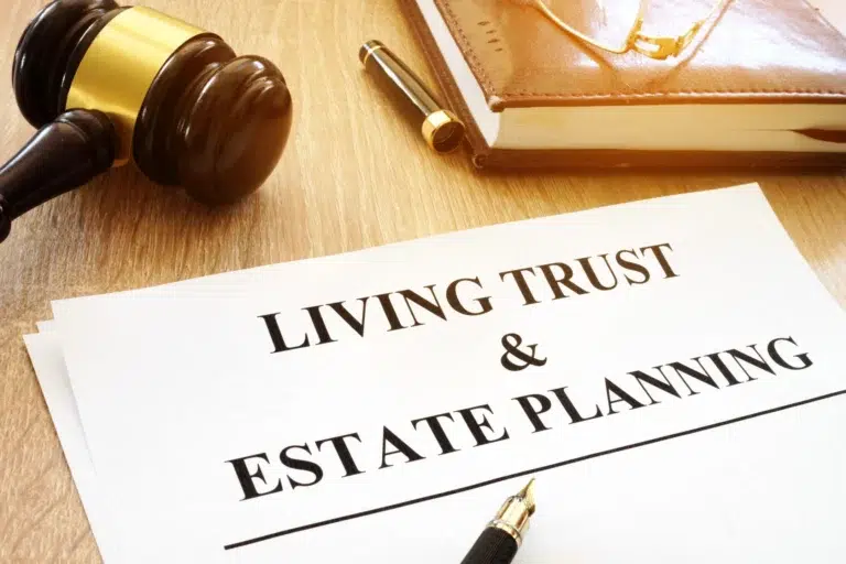 A document titled “Living Trust & Estate Planning” on a wooden desk with a gavel, fountain pen, and leather-bound notebook.