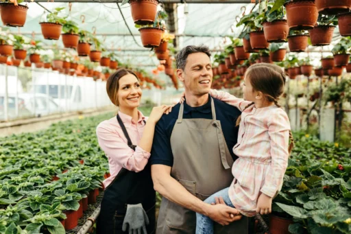 Family standing together in a greenhouse, symbolizing teamwork and shared responsibility in a family business.