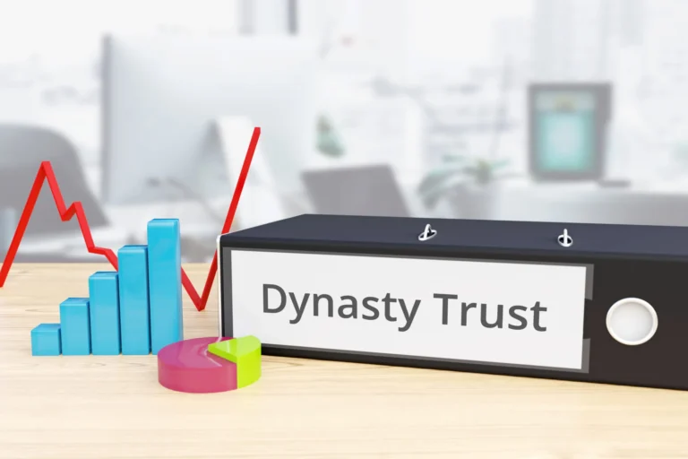 Office binder labeled “Dynasty Trust” on a desk beside colorful financial charts and graphs.
