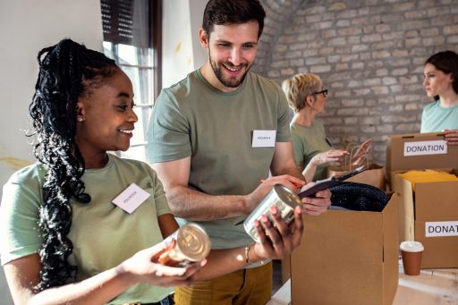 Volunteers sorting canned goods and clothing donations at a community charity event.