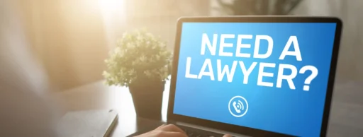 Person typing on a laptop with the words “Need a Lawyer?” displayed on the screen